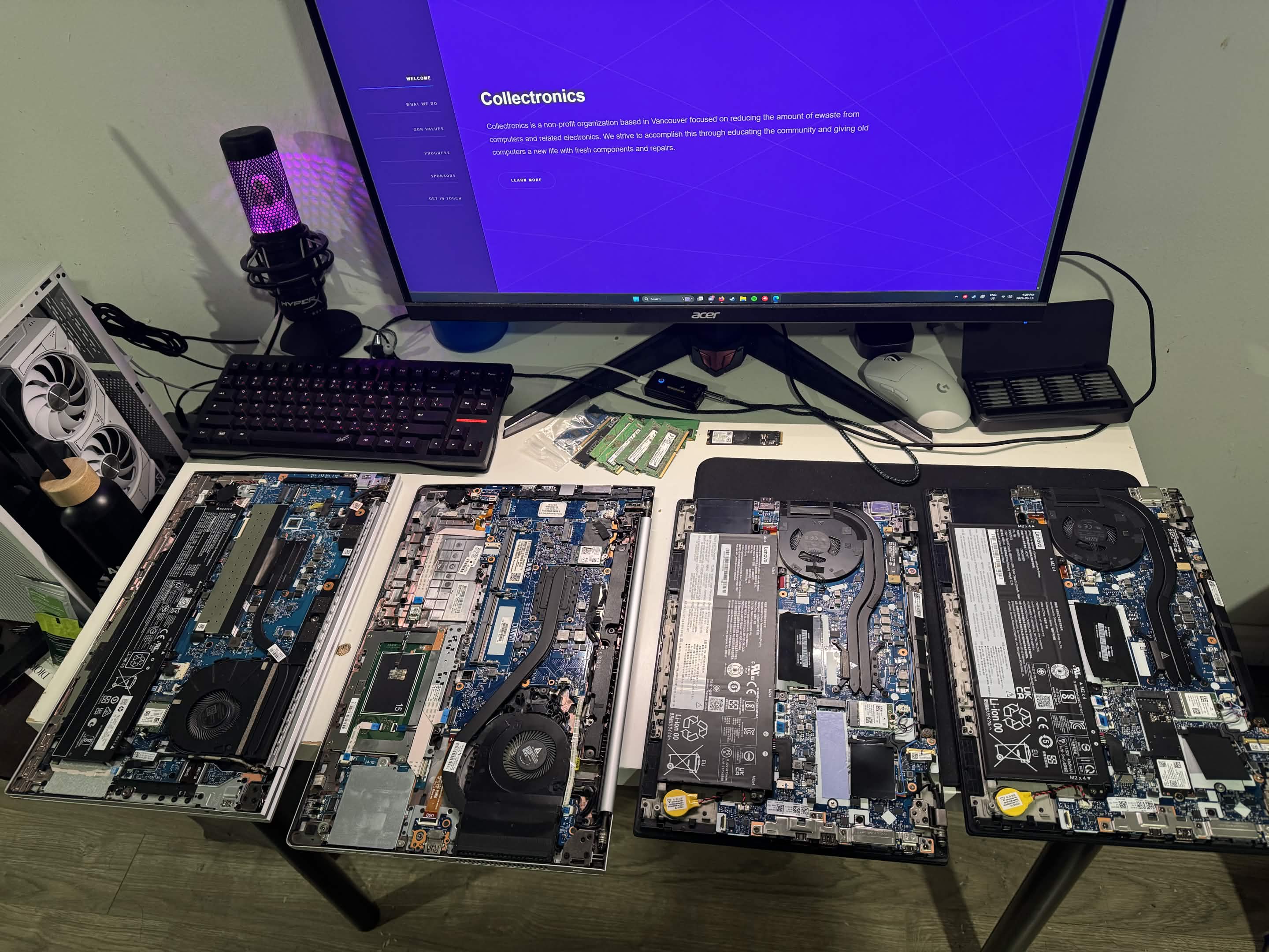 Four open laptops on a workbench